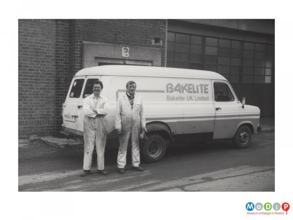 Scanned image showing two male employees and a van.