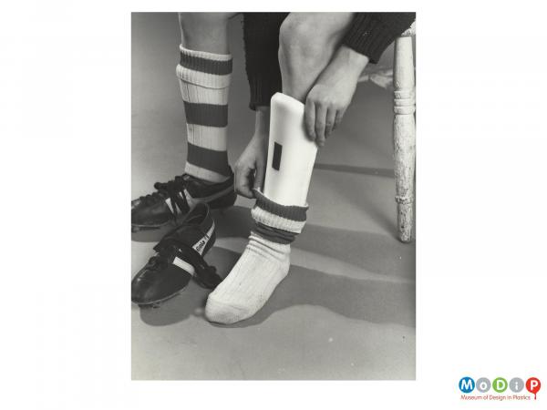 Scanned image showing shin pads in use.