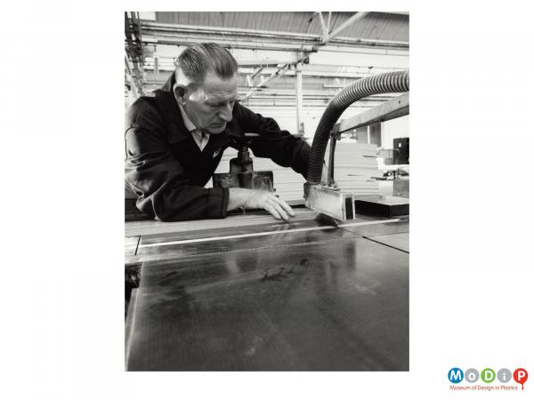 Scanned image showing a male worker using a circular saw.