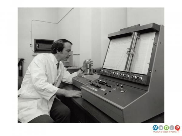 Scanned image showing a man using a piece of testing equipment.