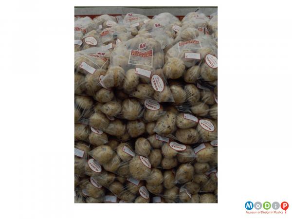 Scanned image showing a stack of bagged potatoes.