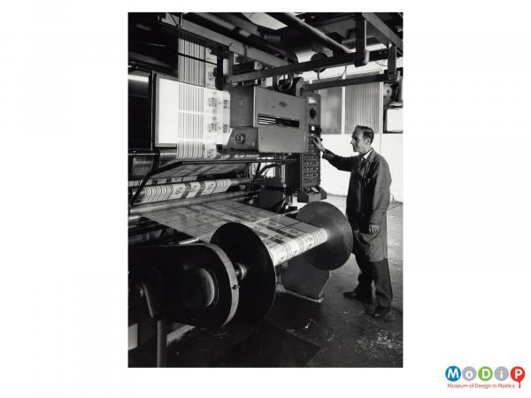 Scanned image showing a man at a printing machine.