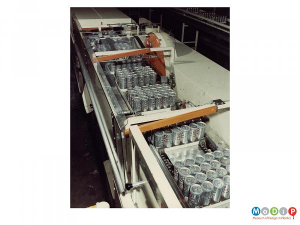 Scanned image showing beer cans on a packaging line.