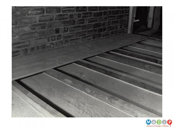 Scanned image showing  Plastazote strip used under flooring to lower sound levels.