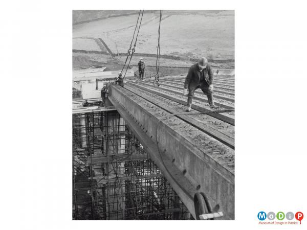 Scanned image showing construction workers building a bridge.