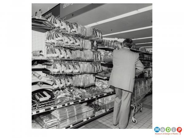 Scanned image showing a man shopping a in a supermarket.