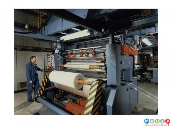 Scanned image showing a machine with a roll of sheet material at the front.