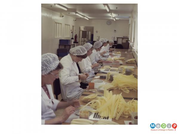 Scanned image showing a row of female employees wearing hair nets. 