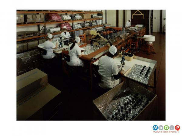 Scanned image showing female employees making winebox liners.