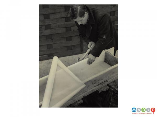 Scanned image showing a concrete mould being lined with plastic sheeting.