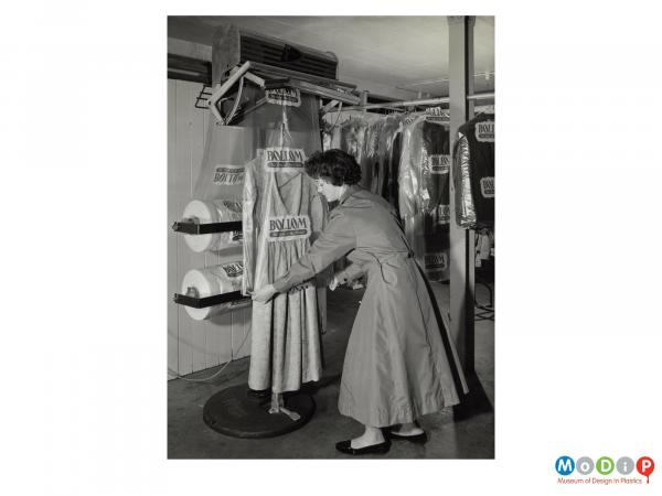 Scanned image showing a machine to assist with covering garments after dry cleaning.