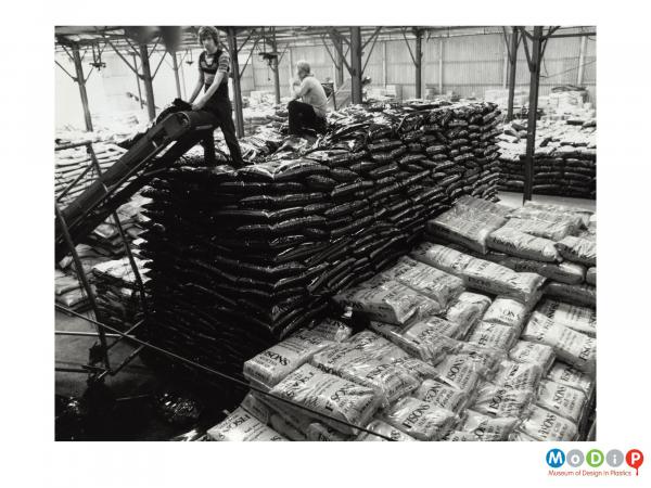Scanned image showing stacks of filled sacks of gardening consumables.