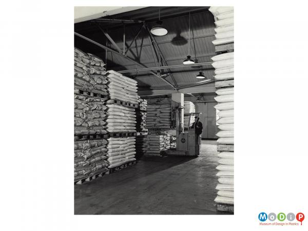 Scanned image showing pallet loads of stacked sacks.