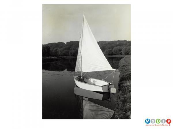 Scanned image showing a small sailing boat on the water.