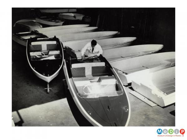 Scanned image showing motor boats being made.
