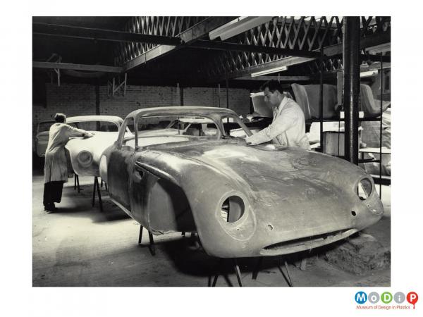 Scanned image showing a sports car being made.