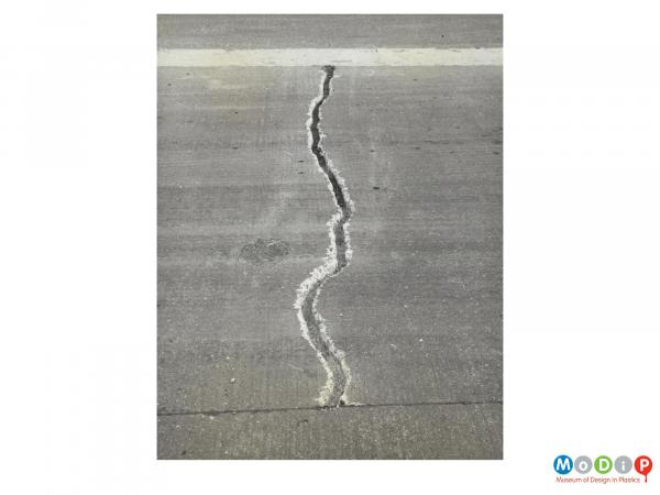 Scanned image showing a large crack in a road surface.