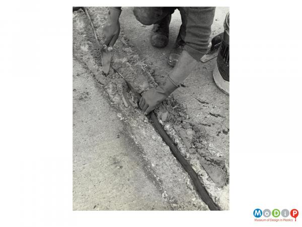 Scanned image showing the repair of a crack in a road surface.