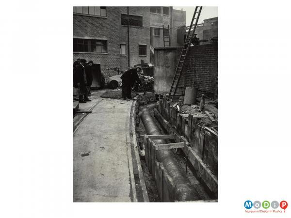 Scanned image showing the laying of pipe.