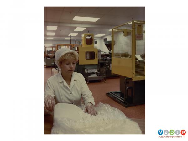 Scanned image showing a female worker with a bag and a scoop.