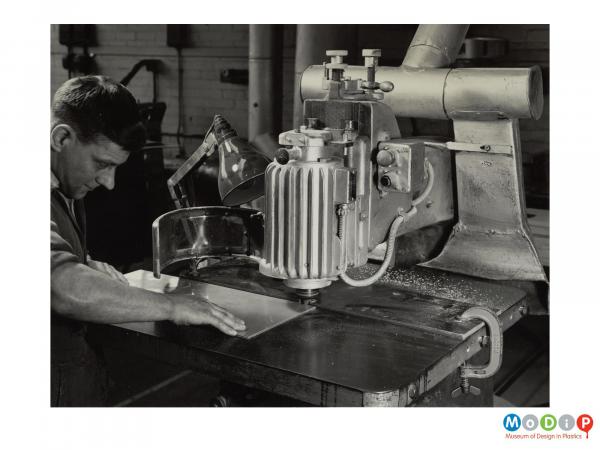 Scanned image showing a man using a mounted router.