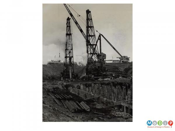 Scanned image showing large cranes and pile drivers.