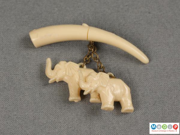 Front view of a brooch showing the hanging elephants.