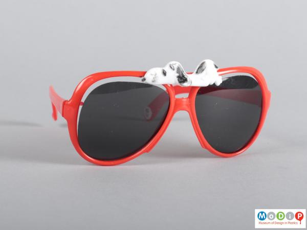 Front view of a pair of sunglasses showing the dog figure on the top.