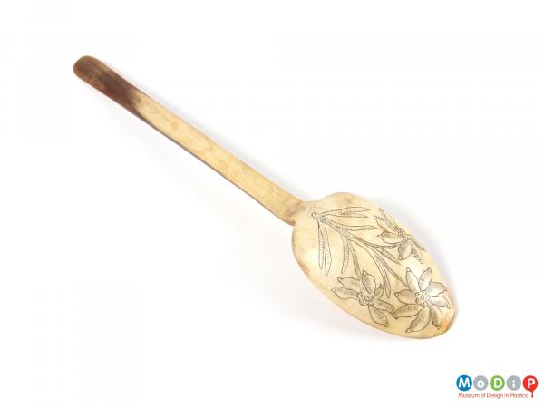 Underside view of a spoon showing the decorated bowl and plain handle.