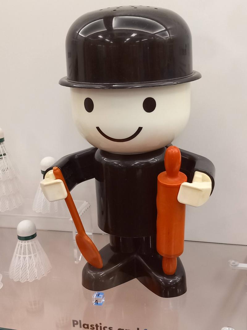 A cartoon character figure with a bowler hat.  The character is holding a spoon and a rolling pin.