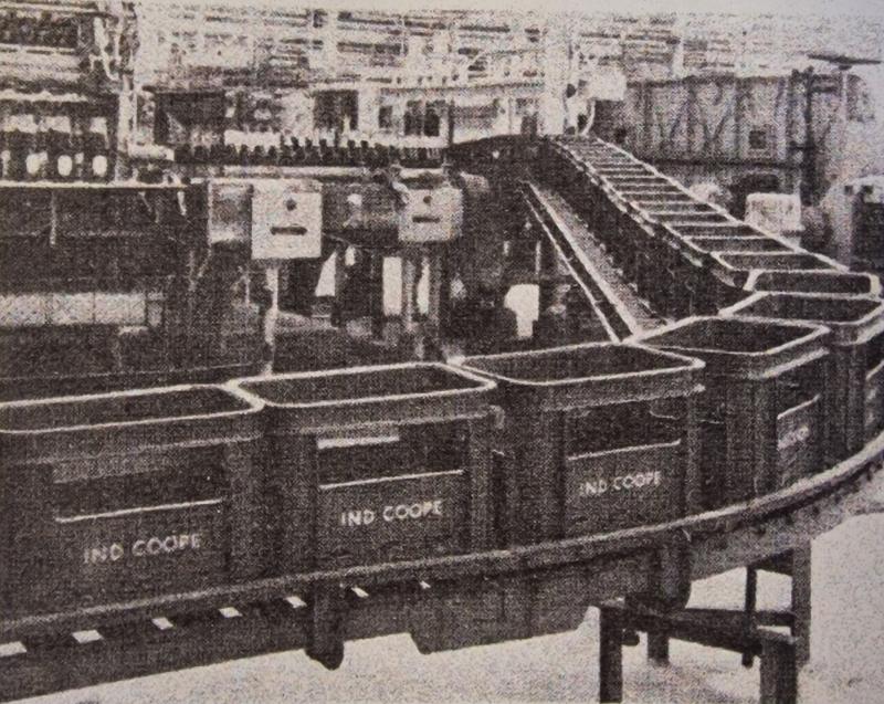 An industrial conveyor belt loaded with labelled plastic crates for the Ind Coope Brewery. 