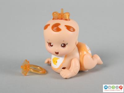 Side view of a Tomy Micro Babies showing the doll and her dummy which can be worn as a ring.