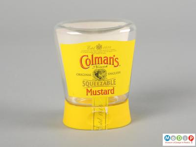 Front view of a Colman's Mustard jar showing the fluted side and flat lid.