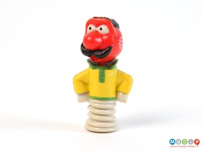 Side view of a pencil topper showing the character holding his arms on his hips.