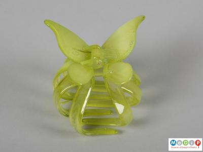 Side view of a hair clamp showing the gripping legs and decorative wings.