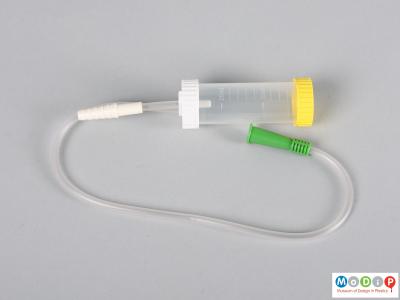 Side view of a mucus extractor showing the tubing and chamber.